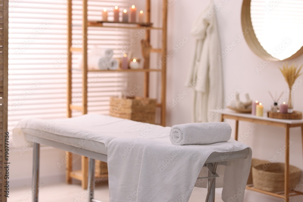 Comfortable massage table with clean towels in spa center Comfortable massage table with clean towels in spa center