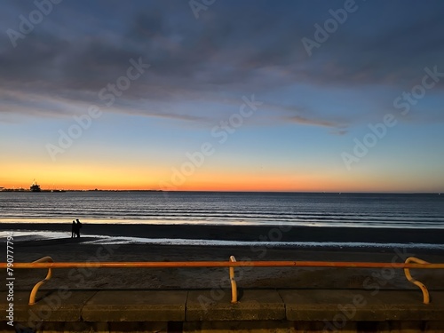 Solitudes embrace: a serene stroll along sunsets shore photo