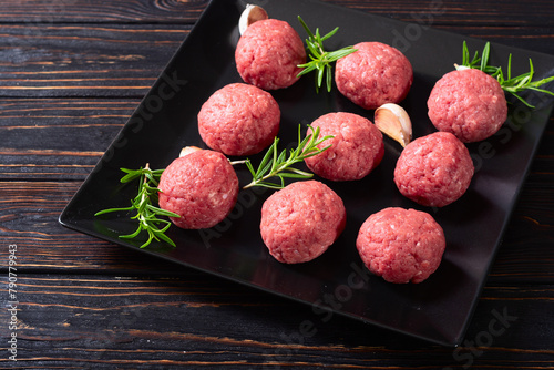 Raw beef meatballs on wooden background