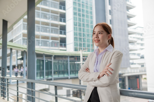 Businesswoman standing on a walkway office, happy smiling young asian woman standing at office