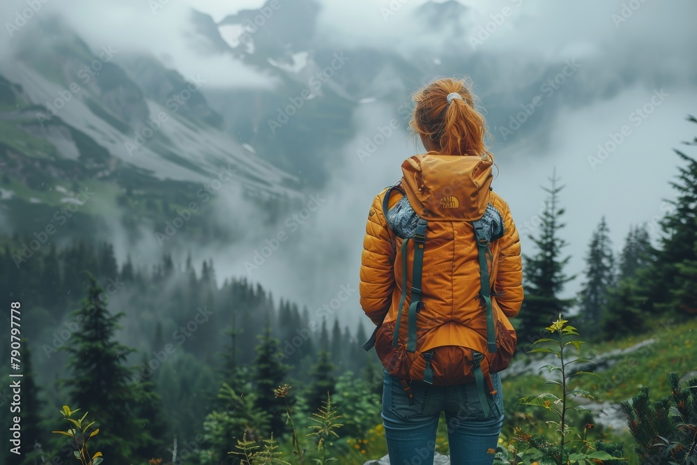 A hiker gazes into a serene scene of pine trees and fog-covered mountains, embodying the essence of calm and discovery