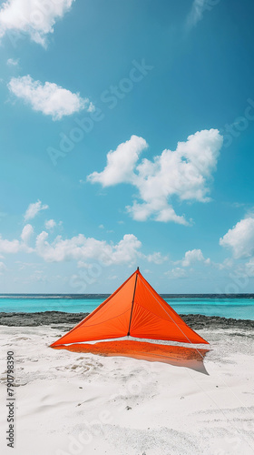 Orange tent on a serene beach with clear blue sky