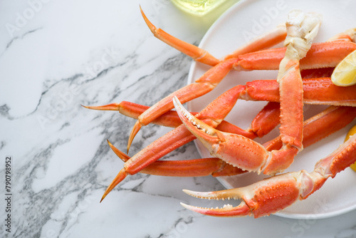 Boiled legs and claws of opilio or snow crab on a white marble background, horizontal shot with space