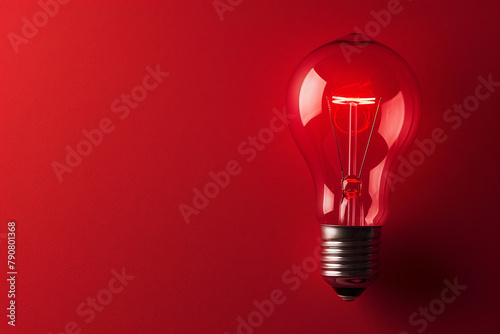 Glowing light bulb on red background. The concept of emerging idea. With copy space
