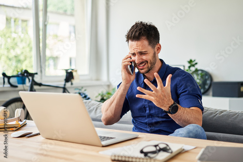 Angry man during phone call working from home © baranq