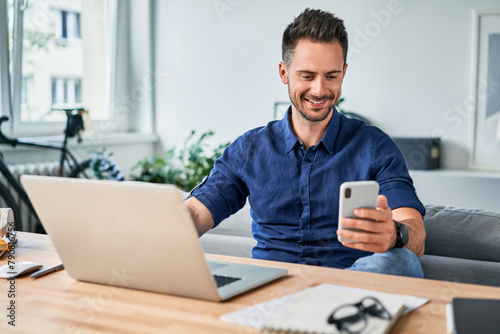Smiling adult man working from home office © baranq