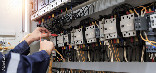 Electricity and electrical maintenance service, Engineer hand holding AC voltmeter checking electric current voltage at circuit breaker terminal and cable .	
