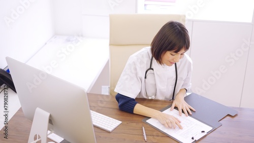 Female doctor consulting a report in her office