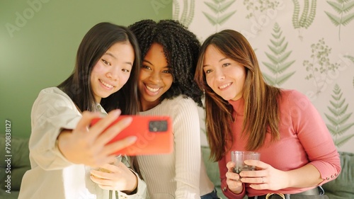 Multi-ethnic friends smiling taking a selfie indoors