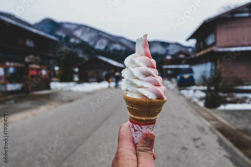 ice cream cone in a hand with city background