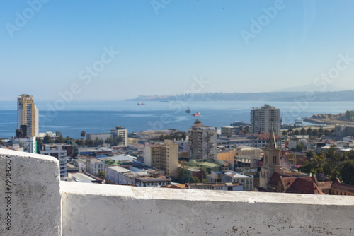 Vista panorâmica de Valparaíso, Chile, em dia ensolarado de verão. O mar ao fundo complementa as casas coloridas em primeiro e segundo plano, capturando a beleza desta cidade costeira