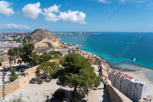 View of the Sangueta Viewpoint from the Santa Barbara Fortress. Tourists, azure water, beach, flying seagulls. Place located in Alicante, Costa Blanca, Spain