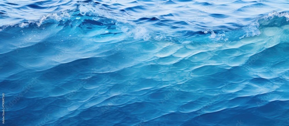 A wave crashing in the ocean under clear blue skies A wave crashing in the ocean under clear blue skies
