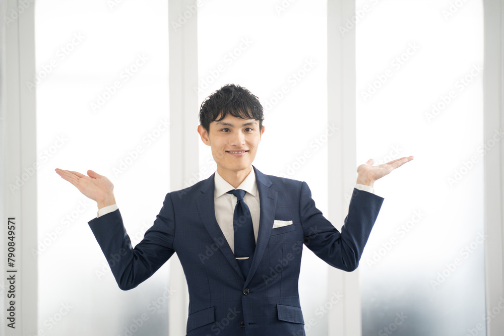 両手を挙げて比較する男性ビジネスマン 両手を挙げて比較する男性ビジネスマン