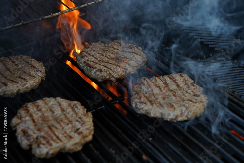 grilled meat burger patties on the grill kissed by a flame