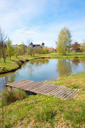 small lake with boardwalk, view to moated castle Schwindegg, upper bavaria