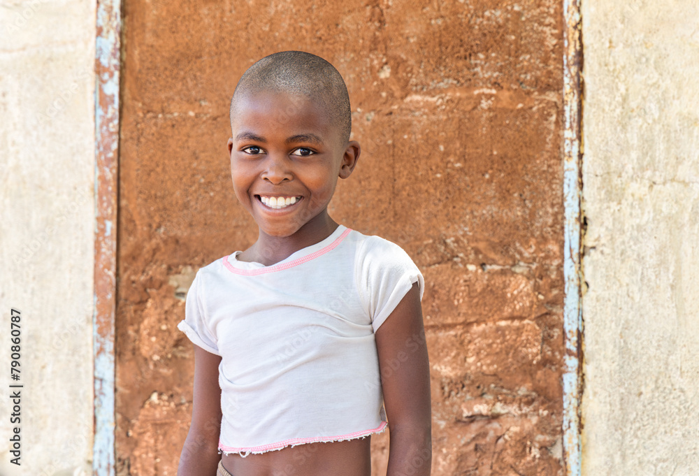 portrait of a village african child, in front of the wall of the house portrait of a village african child, in front of the wall of the house