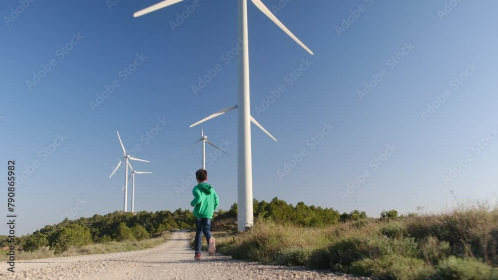 custom made wallpaper toronto digitalA joyful 6-year-old boy runs freely through a field, surrounded by towering windmill turbines, symbolizing hope for a sustainable, green energy future amidst the challenges of climate change