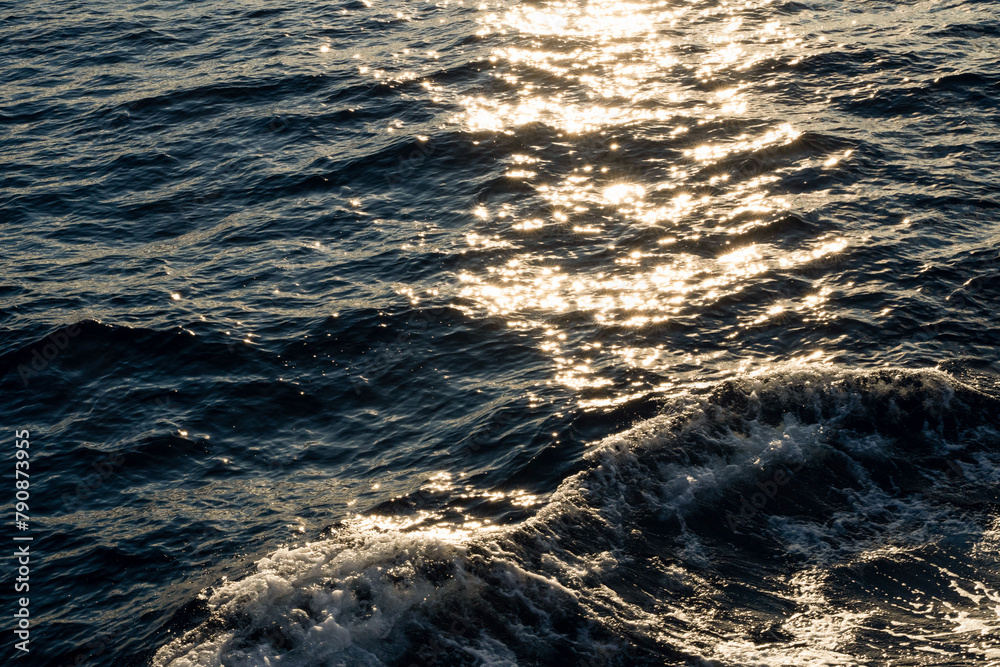 Lens star formed on water body on a sea, A calm ocean reflects sun stars in the morning light and foamy water