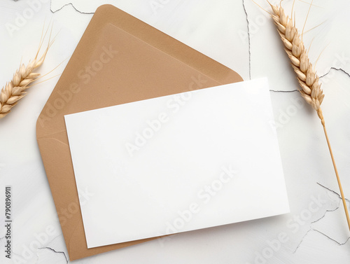 Mockup professionnel épuré d'un carton d'invitation blanc sur fond blanc-gris, touche de charme estival avec des brins de blé photo