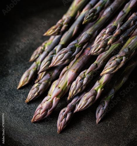 Purple asparagus on a black background, close up view