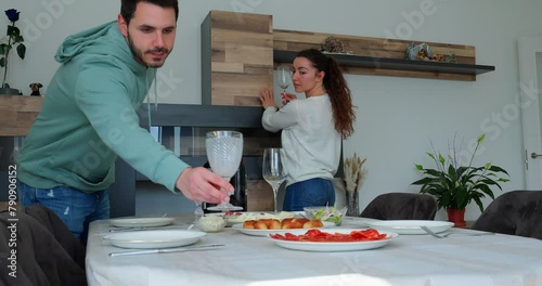 happy couple setting the table together to receive friends photo
