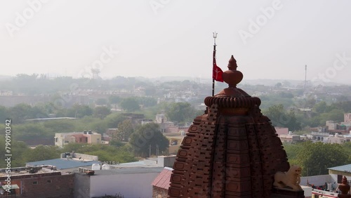 ancient hindu temple with waving holy flag and misty city background from at morning photo