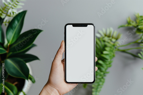 Close up person holding a phone with a mockup in hand on a simple background, a smartphone with a white screen to insert any image