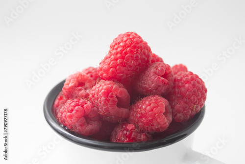 Fresh red ripe organic raspberry in a mug
