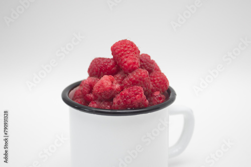 Fresh red raspberry berry in a mug