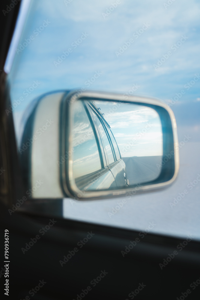 Uyuni Salt flats in Bolivia (Salar of Uyuni) landscape in the sideview mirror of a all-terrain car