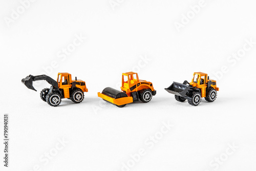 Yellow and black toys of public works vehicles on a white background