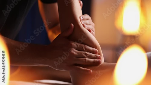 Male masseurs hands press female visitors leg, relaxing massage in spa salon. Body care for young woman.Therapeutic procedure for an injured leg, restoration of health. photo
