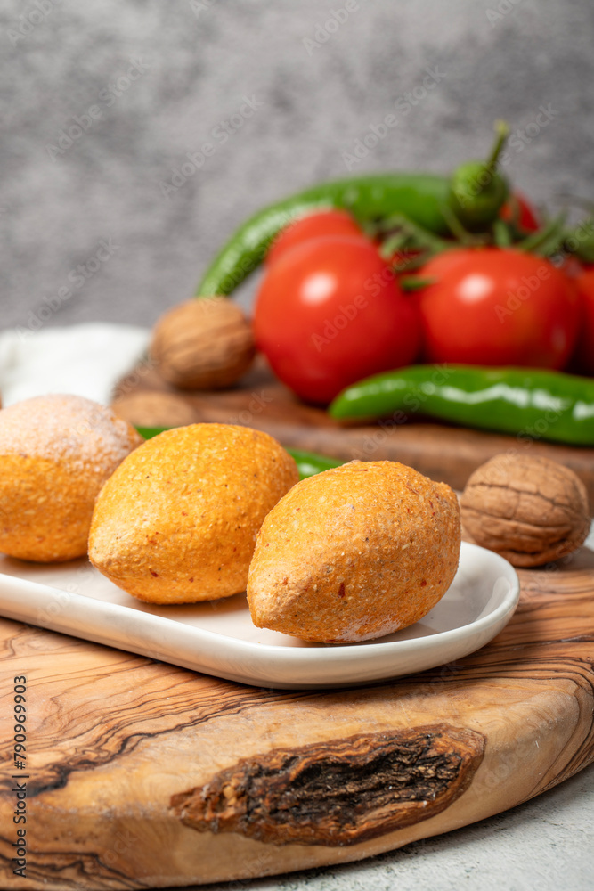 Uncooked frozen stuffed meatballs. Kibbeh or kibbeh on a wooden serving board. Close up Uncooked frozen stuffed meatballs. Kibbeh or kibbeh on a wooden serving board. Close up