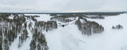 Aerial view over taiga landscape with snow covered boreal forest and frozen lakes in northeast Finland  © Chris
