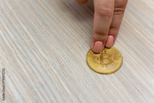 Finger and thumb carefully trace the b on the gold coin