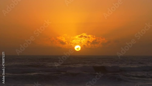 Idyllic golden sunset time lapse over the ocean. Sun setting below horizon.
