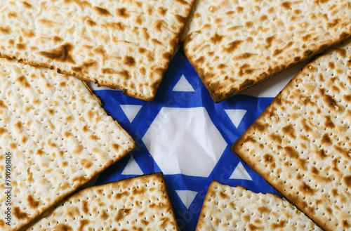 Matzo, an unleavened flatbread, arranged around a blue and white Star of David. The star is prominent, symbolizing Jewish identity and heritage, making this image representative of jewish passover photo