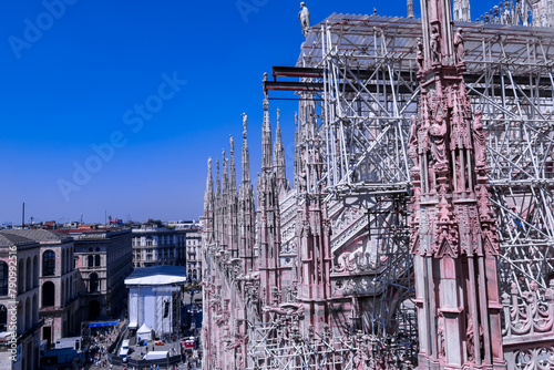 View of Milan Cathedral (Duomo di Milano) and the city from the rooftop, Milan, Lombardy, Italy, Europe. Historical marble facade with spires. Gothic architecture features. City travel tourism
