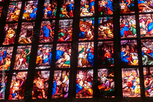 Interior view of Milan Cathedral (Duomo di Milano), Lombardy, Italy, Europe. Gothic architecture. Colored stained glass window in a church, depicting various scenes from the life of Jesus Christ