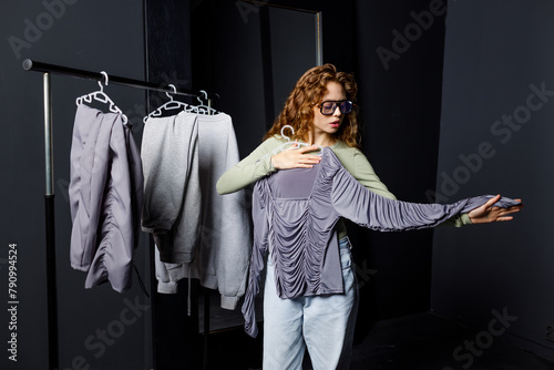 Young beautiful woman choosing clothes at fitting room. Shopping concept