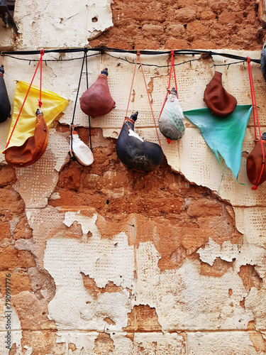 Hanging Wineskins. Closeup of series of handmade curved wineskin of different sizes and colors. Leather goods and traditional crafts.