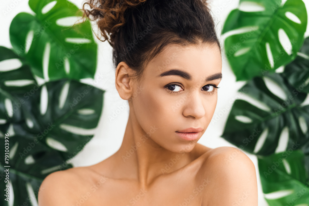 Serene half-naked black woman among green leaves Serene half-naked black woman among green leaves
