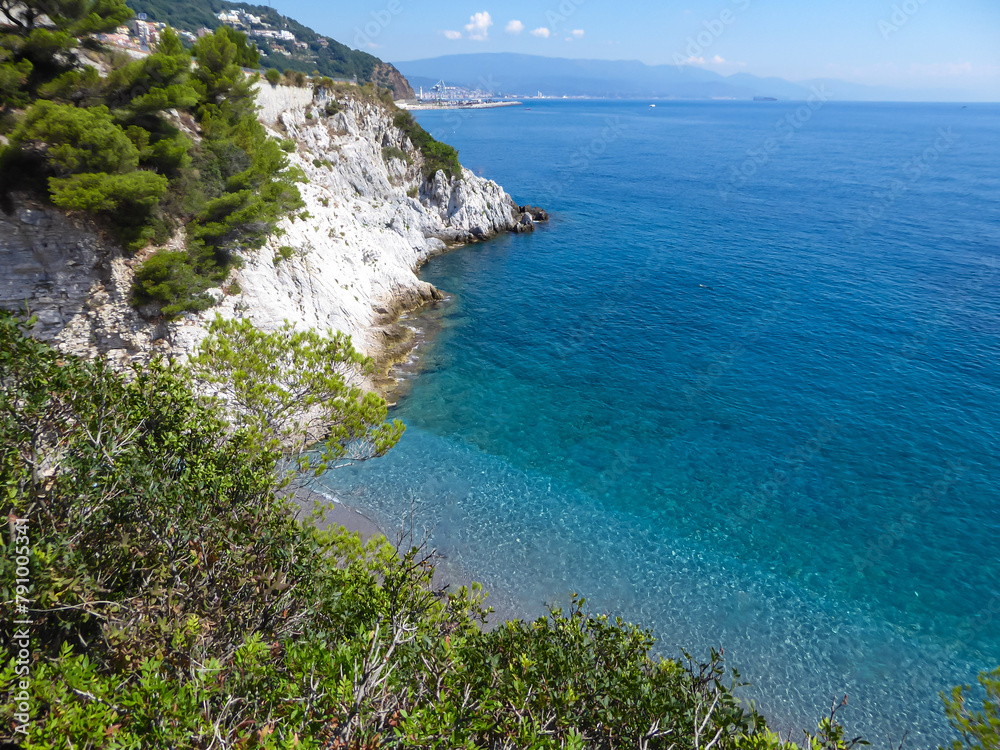 Scenic view of hidden beach of Spiaggia lido delle sirene along the Ligurian coast in Italy, Europe. Beautiful coastline of the Adriatic Mediterranean sea in summer. Clear clean turquoise water