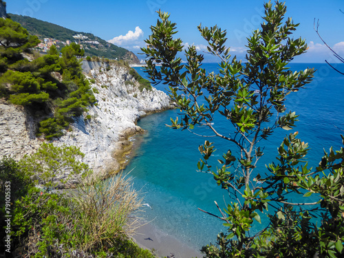 Scenic view of hidden beach of Spiaggia lido delle sirene along the Ligurian coast in Italy, Europe. Beautiful coastline of the Adriatic Mediterranean sea in summer. Clear clean turquoise water photo