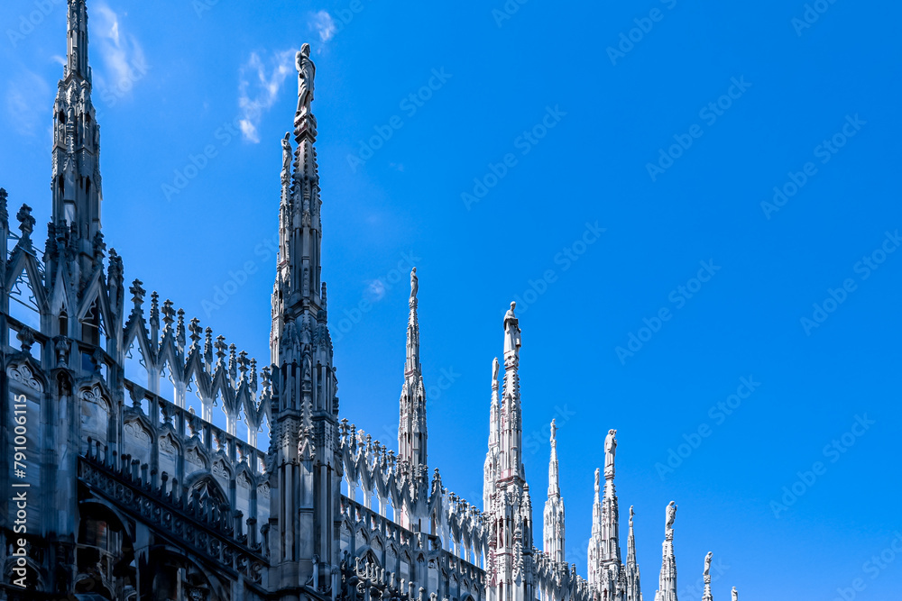 External view of Milan Cathedral (Duomo di Milano) from the rooftop, Milan, Lombardy, Italy, Europe. Historical marble facade with spires. Gothic architecture features. City travel tourism