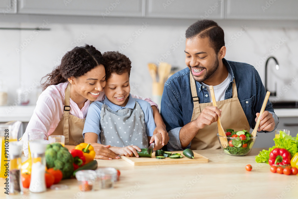 African American family working together in kitchen