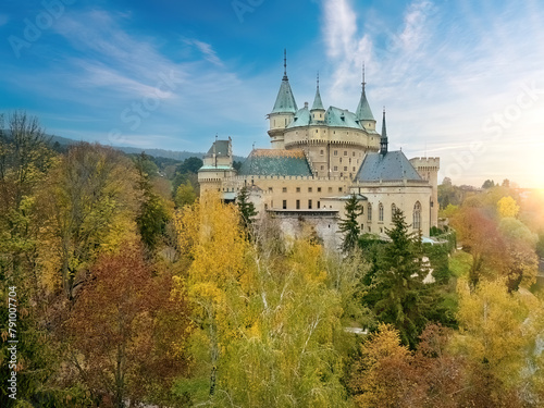 Panoramic View of romantic Bojnice Castle within Vivid Fall Colors garden, blue sky - Ideal for Poster, UNESCO Heritage, Slovakia.