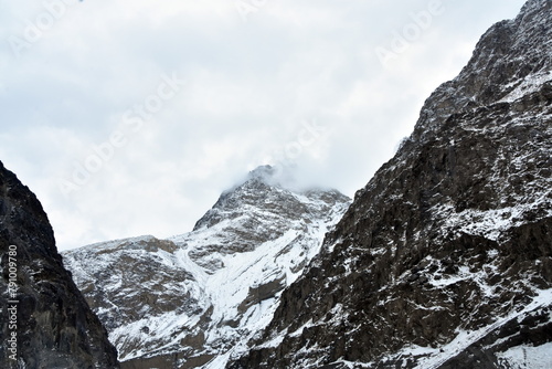 Snow-capped mountain peak amongst rugged cliffs