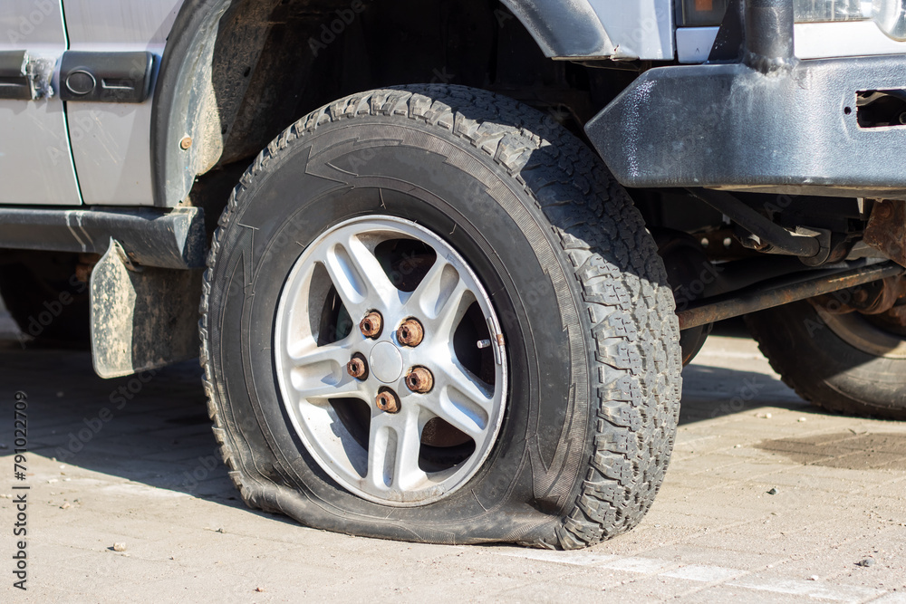 A flat tire on road side, car wheel stuck, needs repair